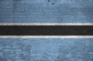 Botswana flag depicted in paint colors on old brick wall. Textured banner on big brick wall masonry background photo