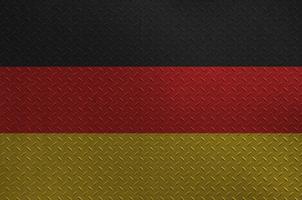 Germany flag depicted in paint colors on old brushed metal plate or wall closeup. Textured banner on rough background photo