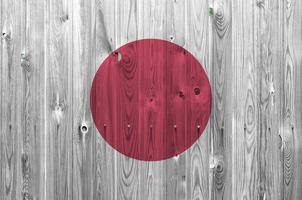 bandera de japón representada en colores de pintura brillante en la pared de madera vieja. banner texturizado sobre fondo áspero foto