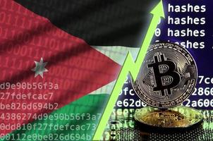 bandera jordana y flecha verde ascendente en la pantalla de minería bitcoin y dos bitcoins dorados físicos foto