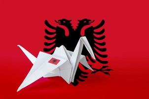 Albania flag depicted on paper origami crane wing. Handmade arts concept photo