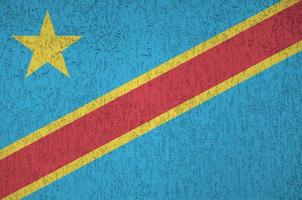 Democratic Republic of the Congo flag depicted in bright paint colors on old relief plastering wall. Textured banner on rough background photo