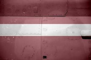 Latvia flag depicted on side part of military armored helicopter closeup. Army forces aircraft conceptual background