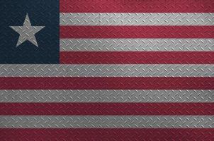 Liberia flag depicted in paint colors on old brushed metal plate or wall closeup. Textured banner on rough background photo