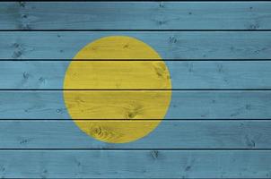 Palau flag depicted in bright paint colors on old wooden wall. Textured banner on rough background photo