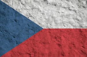 Czech flag depicted in bright paint colors on old relief plastering wall. Textured banner on rough background photo