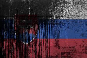 Slovakia flag depicted in paint colors on old and dirty oil barrel wall closeup. Textured banner on rough background photo