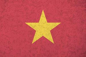 Vietnam flag depicted in bright paint colors on old relief plastering wall. Textured banner on rough background photo