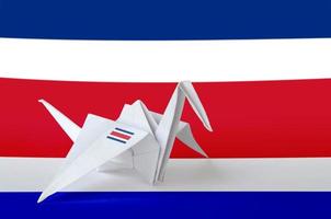 Costa Rica flag depicted on paper origami crane wing. Handmade arts concept photo