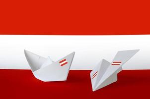 bandera de austria representada en avión y barco de origami de papel. concepto de artes hechas a mano foto