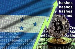 bandera de honduras y flecha verde ascendente en la pantalla de minería bitcoin y dos bitcoins dorados físicos foto