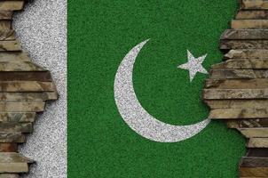 Pakistan flag depicted in paint colors on old stone wall closeup. Textured banner on rock wall background photo