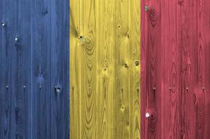 Romania flag depicted in bright paint colors on old wooden wall. Textured banner on rough background photo
