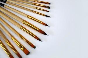 A selection of orange brushes with different sizes on a white surface photo