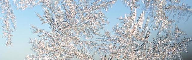 Snowflakes frost rime macro on window glass pane photo