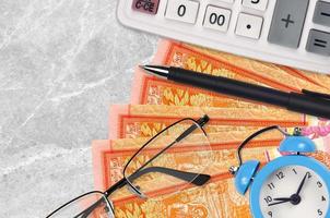 100 Sri Lankan rupees bills and calculator with glasses and pen. Business loan or tax payment season concept. Time to pay taxes photo