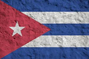 Cuba flag depicted in bright paint colors on old relief plastering wall. Textured banner on rough background photo