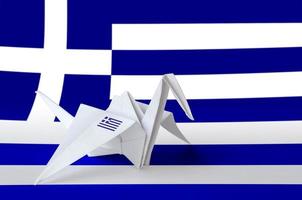 Greece flag depicted on paper origami crane wing. Handmade arts concept photo