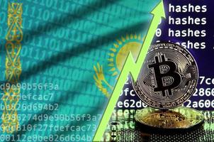 bandera de kazajstán y flecha verde ascendente en la pantalla de minería bitcoin y dos bitcoins dorados físicos foto