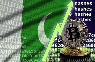 bandera de pakistán y flecha verde ascendente en la pantalla de minería bitcoin y dos bitcoins dorados físicos foto