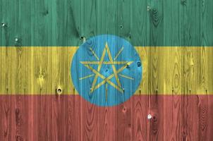 Ethiopia flag depicted in bright paint colors on old wooden wall. Textured banner on rough background photo