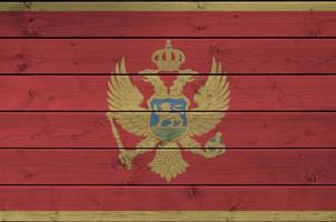 bandera de montenegro representada en colores de pintura brillante en la pared de madera vieja. banner texturizado sobre fondo áspero foto