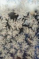 Snowflakes frost rime macro on window glass pane photo