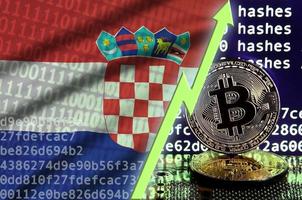 bandera croata y flecha verde ascendente en la pantalla de minería bitcoin y dos bitcoins dorados físicos foto