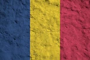 Chad flag depicted in bright paint colors on old relief plastering wall. Textured banner on rough background photo