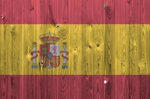 Spain flag depicted in bright paint colors on old wooden wall. Textured banner on rough background photo