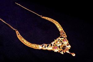 golden necklace is studded with small stones and other tassles with intricate designs photo