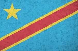 Democratic Republic of the Congo flag depicted in bright paint colors on old relief plastering wall. Textured banner on rough background photo