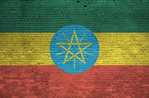 Ethiopia flag depicted in paint colors on old brick wall. Textured banner on big brick wall masonry background photo