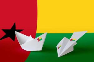 Guinea Bissau flag depicted on paper origami airplane and boat. Handmade arts concept photo