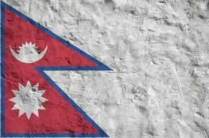 Nepal flag depicted in bright paint colors on old relief plastering wall. Textured banner on rough background photo