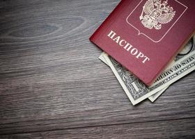 A foreign passport and dollars on a wooden background. photo