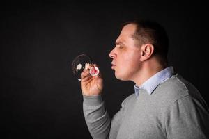 handsome man in a suit is blowing soap bubbles. photo