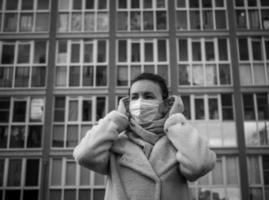 foto de una niña con una máscara, en la calle. pandemia de encierro covid-19.