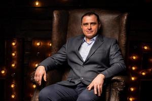 handsome businessman in a suit looks at the camera on a leather chair. photo