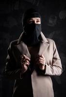 Portrait of a girl in a black balaclava and beige coat. photo