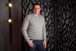 handsome man in a suit poses in an interior studio. photo