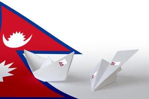 Nepal flag depicted on paper origami airplane and boat. Handmade arts concept photo