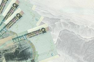 10 billetes de yuanes chinos se encuentran apilados en el fondo de un gran billete semitransparente. fondo de negocios abstracto foto