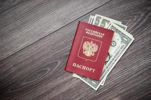 A foreign passport and dollars on a wooden background. photo