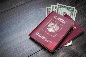 A foreign passport and dollars on a wooden background. photo