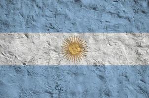 Argentina flag depicted in bright paint colors on old relief plastering wall. Textured banner on rough background photo