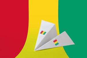 Guinea flag depicted on paper origami airplane. Handmade arts concept photo