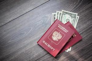 A foreign passport and dollars on a wooden background. photo