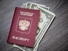 A foreign passport and dollars on a wooden background. photo