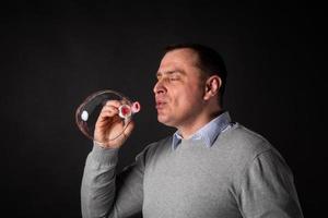 handsome man in a suit is blowing soap bubbles. photo